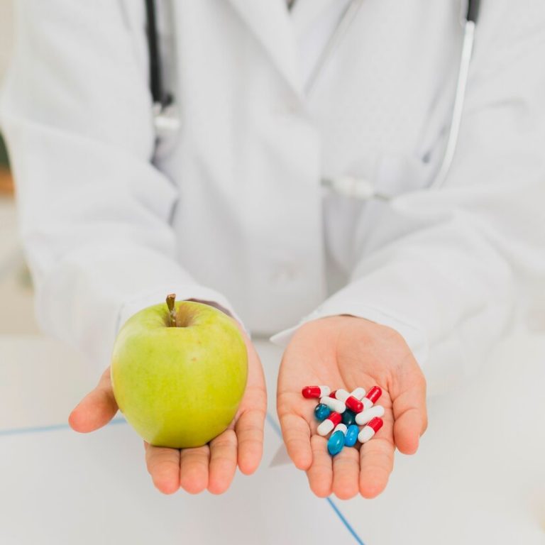 close-up-doctor-holding-green-apple-pills_23-2148302155